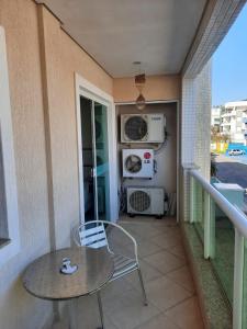 a table and a chair on a balcony at Amplo e confortável apto a 98 metros da praia de Bombinhas in Bombinhas