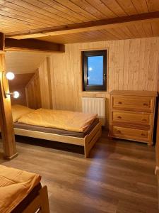 sypialnia z 2 łóżkami i oknem w obiekcie Venkovská chalupa w mieście Jestrabi V Krkonosich