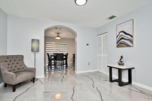 a living room with a chair and a table at Hard Rock Hidden Gem! in Miami Gardens