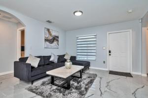uma sala de estar com um sofá preto e uma mesa em Hard Rock Hidden Gem! em Miami Gardens