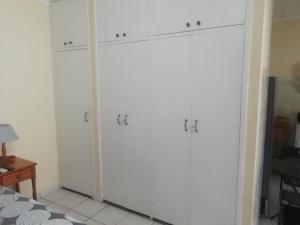 a closet with white doors in a room at Anne's Cottage in Durban +4 photos