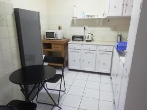 a small kitchen with a table and a microwave at Anne's Cottage in Durban