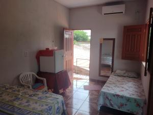 a room with two beds and a door to a yard at Pousada Sombra do Jambeiro in Alter do Chao