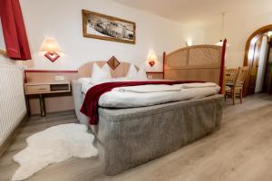 Un dormitorio con una cama grande y una mesa y sillas. en Haus Landmann, en Ellmau