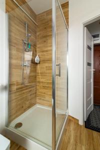 a shower in a bathroom with wooden walls at APARTAMENT ZIELONO MI...... in Jedlina-Zdrój