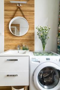 ein Badezimmer mit einer Waschmaschine und einem Spiegel in der Unterkunft APARTAMENT ZIELONO MI...... in Jedlina-Zdrój