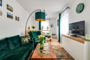 イェドリナ・ズドルイにあるAPARTAMENT ZIELONO MI......の緑のソファとテーブルのあるリビングルーム