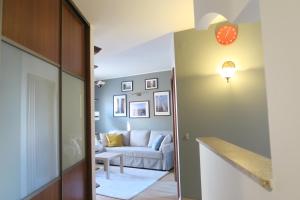 Apartament Geneva في وارسو: غرفة معيشة مع أريكة بيضاء في غرفة