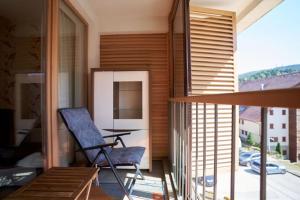a room with a chair and a table on a balcony at The Nest - harmony place to spend a mountain brake in Bjelašnica