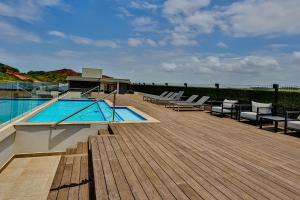 a deck with chairs and a swimming pool on a building at Zimbali Lakes Boulevard Suites 103 in Ballito