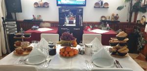 a table with a white table cloth with food on it at VILA VALENCIA in Azuga