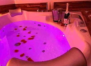 a hot pink bath tub with a bottle of wine at Séjour détente au cœur de MÂCON avec spa et bouteille offerte in Mâcon