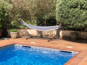 a hammock sitting next to a swimming pool at Chalet entre parques naturales in Vallgorguina