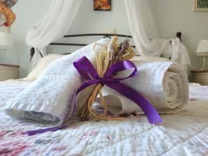 ręcznik z fioletową wstążką na łóżku w obiekcie Clear Sunset w Kanalionie