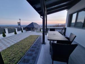 a patio with a table and chairs on a building at Casa de vacanta Larisa in Novaci-Străini