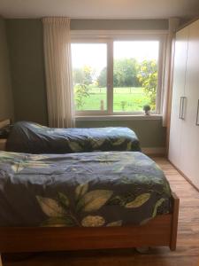 a bedroom with two beds and a large window at Raafjeshof in Culemborg