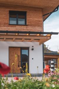 a house with a wooden door in a yard at Ferienwohnung Das LechSide in Pflach