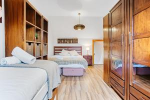 1 dormitorio con 2 camas y armarios de madera en MELLER - Garaje, Wifi, parada esquí bus a 200 mts, en Formigal