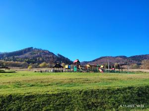 einen Spielplatz auf einem Feld mit einem Hügel im Hintergrund in der Unterkunft APARTAMENT ZIELONO MI...... in Jedlina-Zdrój