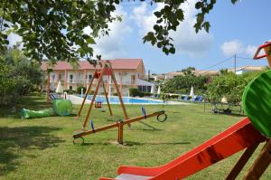 een park met een speeltuin met een schommel bij Aggelos Family Hotel in Moraitika