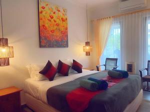 una camera da letto con un grande letto con cuscini sopra di Villa Cantik Kuta Regency a Kuta