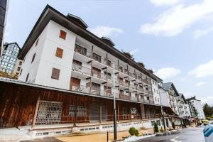 un edificio blanco con balcones en una calle en MELLER - Garaje, Wifi, parada esquí bus a 200 mts, en Formigal