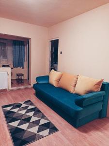 Un sofá azul en una sala de estar con suelo a cuadros. en KID Apartments, en Cluj-Napoca
