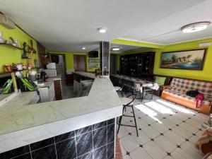 uma cozinha e sala de estar com paredes amarelas e um balcão em Casa Laguna Sentiz 