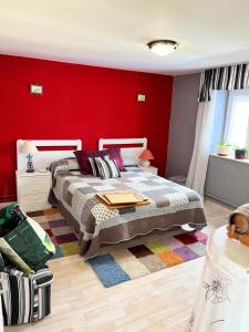 um quarto com uma cama e uma parede vermelha em Casa Laguna Sentiz 