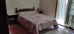 a bedroom with a bed with a pink blanket at Cataratas alojamiento in Puerto Iguazú