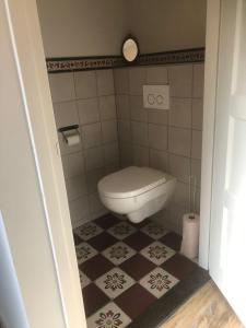 a bathroom with a toilet and a tiled floor at Raafjeshof in Culemborg