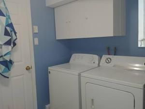 baño con lavadora y pared azul en L ' Arlequin Suite et logement, en Vaudreuil-Dorion 13 fotos más