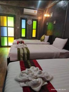 um grupo de quatro camas num quarto em The Chater@kangkud em Ban Muang Kut