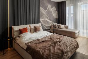 a bedroom with a bed and a couch in it at Mandala A Designer Penthouse with Free Private Parking, near Mall Coresi in Braşov