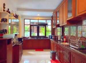 a large kitchen with wooden cabinets and a large window at Villa Cantik Kuta Regency in Kuta