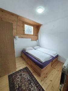 een kleine slaapkamer met een bed en een raam bij Apartments A Vlasic in Vlasic