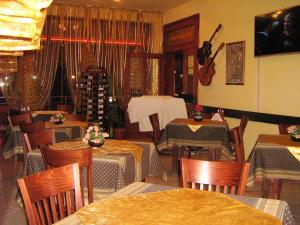 un ristorante con tavoli e sedie e una chitarra appesa al muro di Hotel Blian a Ravda