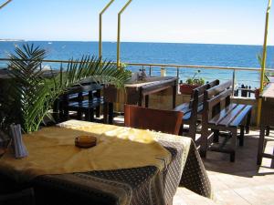 un patio con tavoli e sedie e vista sull'oceano di Hotel Blian a Ravda