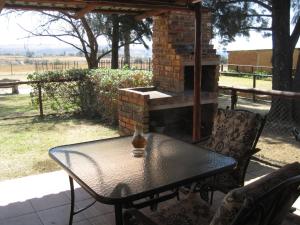 a table and chairs on a patio with a brick oven at Blue Roan Country Lodge in Vlakfontein