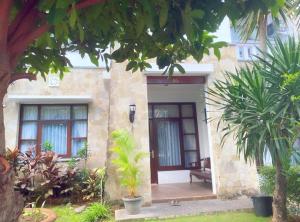 Villa Cantik Kuta Regency في كوتا: منزل أمامه جلسة