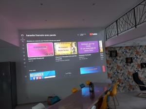 een groot projectiescherm op een muur in een kamer bij gîte de l'atelier 15 personnes in Grazac