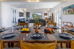 a dining room and living room with a table and chairs at Villa Pasifika in Loutraki