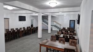a room with chairs and tables and a staircase at Casa de vacanta Larisa in Novaci-Străini