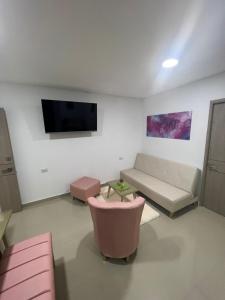 a living room with a couch and a flat screen tv at Hotel Wanderlust in Santa Marta
