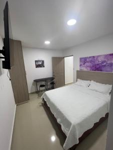 a bedroom with a large bed and a desk at Hotel Wanderlust in Santa Marta
