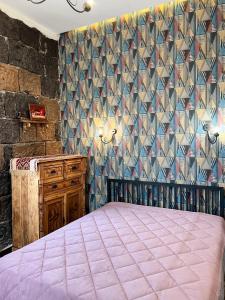 una camera con letto viola e parete di Aros Apartment a Gyumri