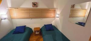 2 camas individuales en una habitación con almohadas azules en Le Skisun - Massif et Parc national des Ecrins - Puy Saint Vincent 1800, en Puy-Saint-Vincent