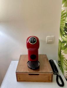 une cafetière rouge assise sur une table en bois dans l'établissement Tropik-Appart - Studio, à Sainte-Luce