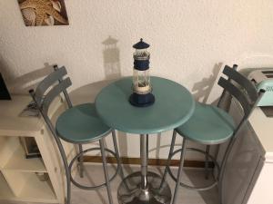 a table with chairs and a lamp on top of it at Agréable studio Barcares in Le Barcarès