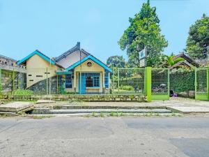 a house with a green gate in front of it at SPOT ON 2275 Omah Jm in Beran-kidul